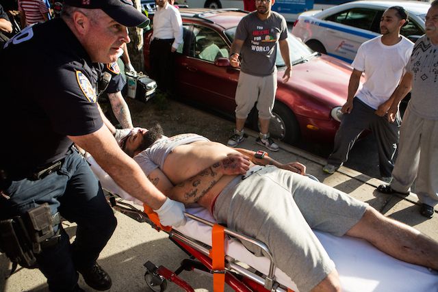 The victim of an August shooting at Brooklyn's Farragut Houses is rushed to an ambulance by the NYPD.